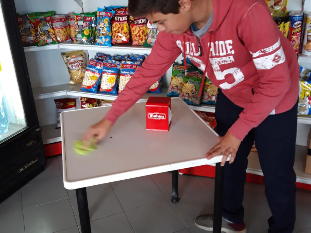 Zwei Jugendliche stellen im Supermarkt einen Tisch auf.